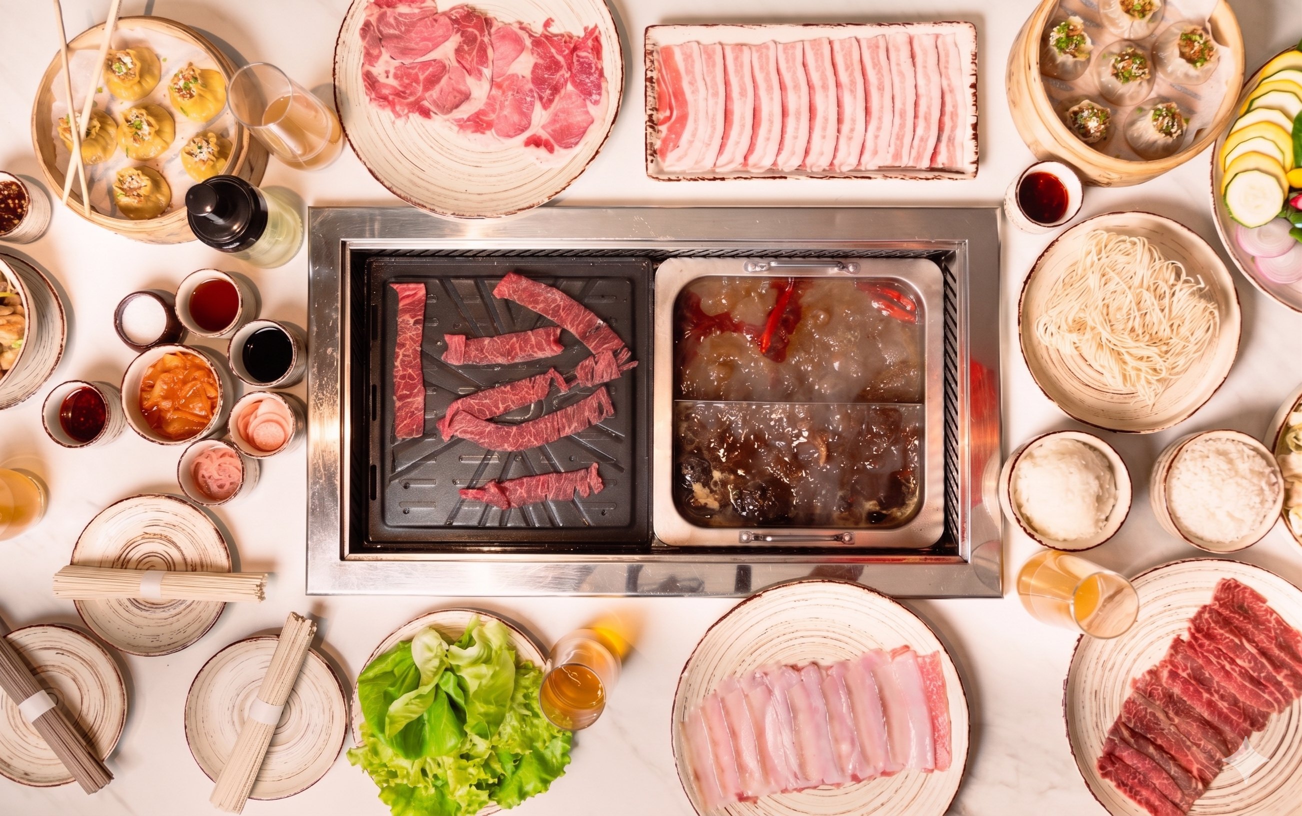 An overhead spread of Korean BBQ and hotpot at Lady Aiko